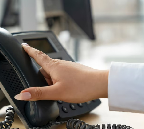 Hand dialing the office phone to reach Insurance Specialists Inc in Brownwood, Texas